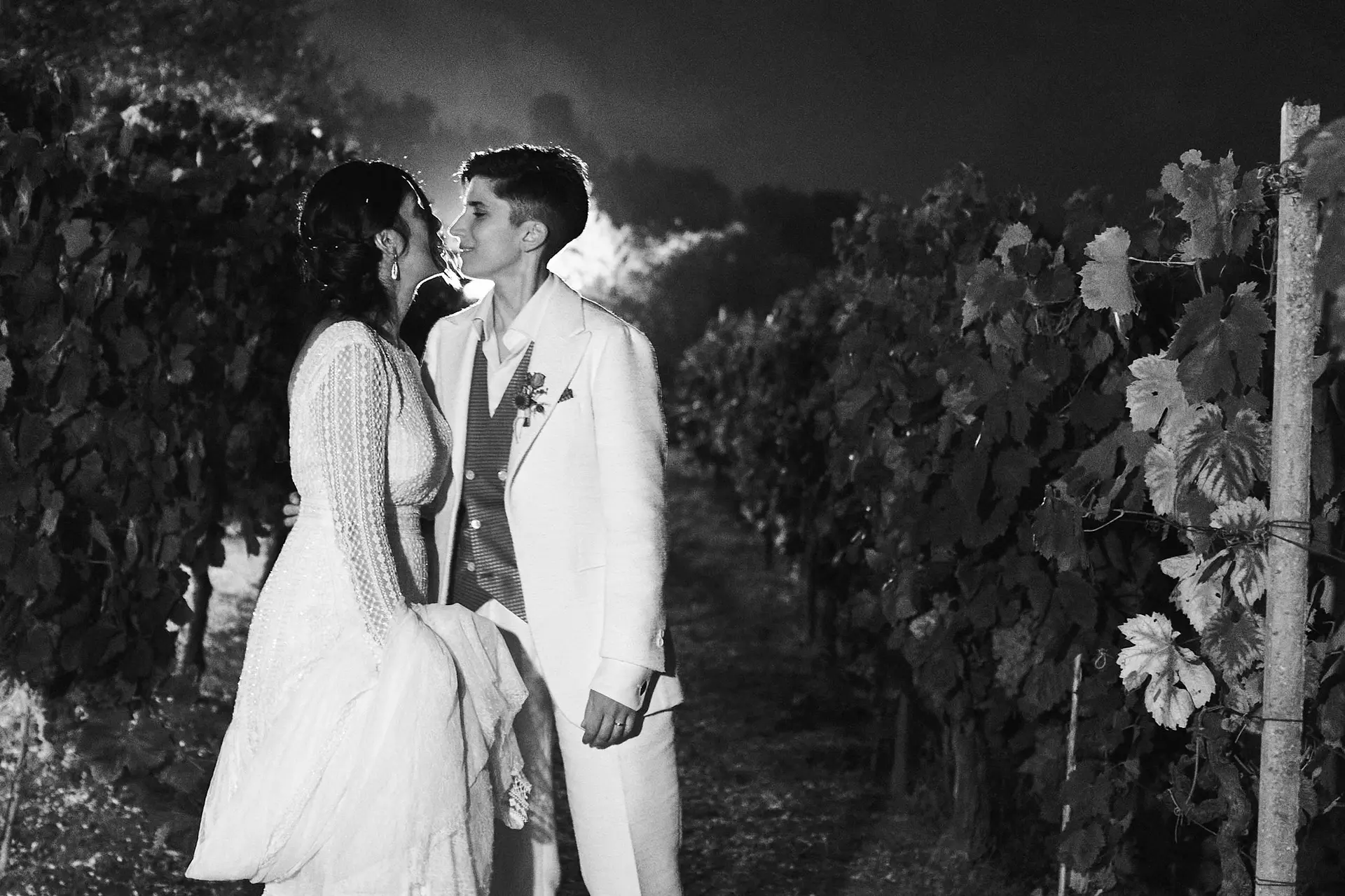 Intimate wedding kiss in a vineyard under stars at night in Italy, romantic and unforgettable celebration of love.