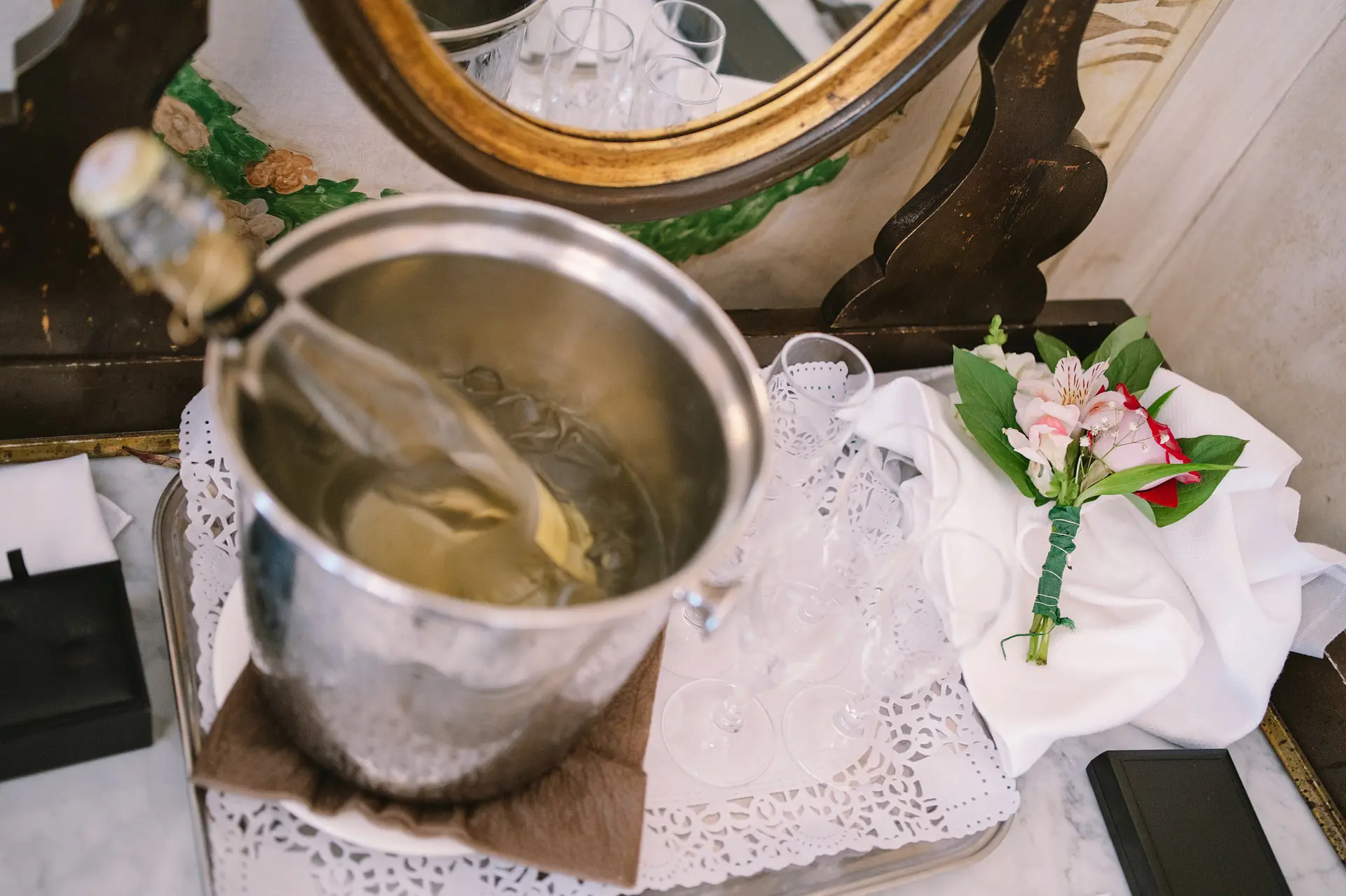 A bottle of champagne chills in an ice bucket. Cheap wedding reception ideas.