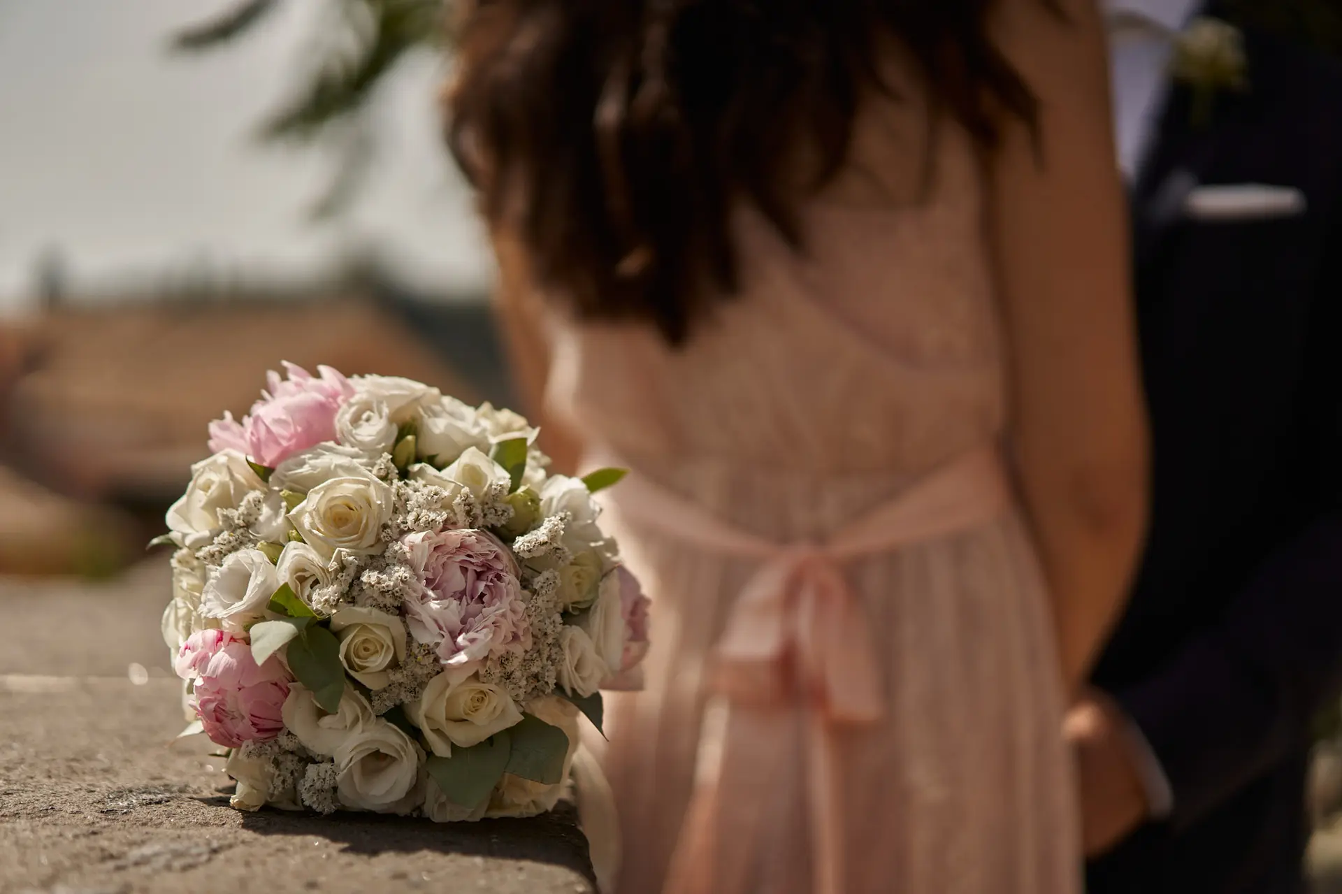 Pink and white wedding bouquet rests on a ledge. Cheap wedding reception ideas.