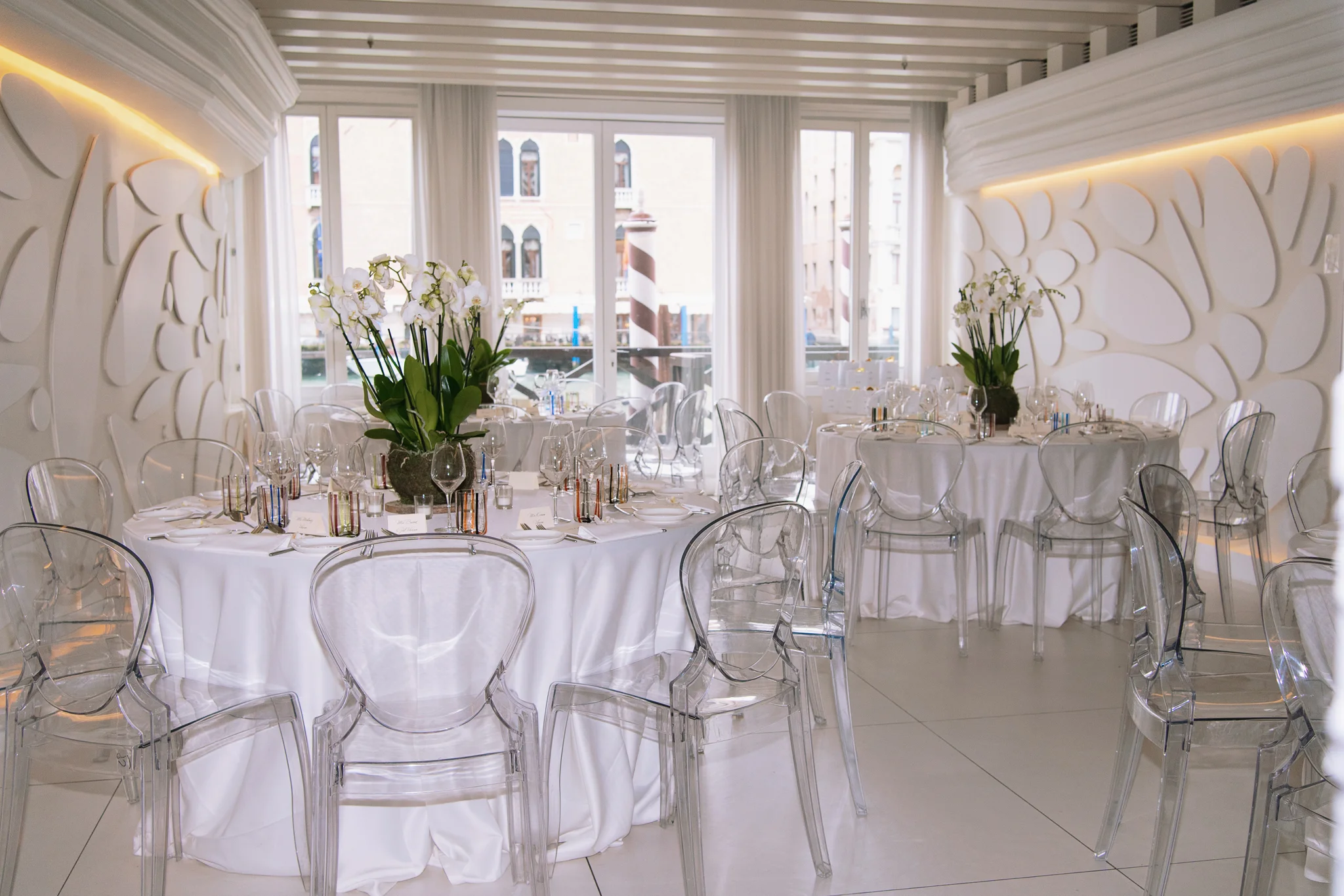 A modern reception setup, a key detail in how to plan a destination wedding in Italy, with chic ghost chairs.