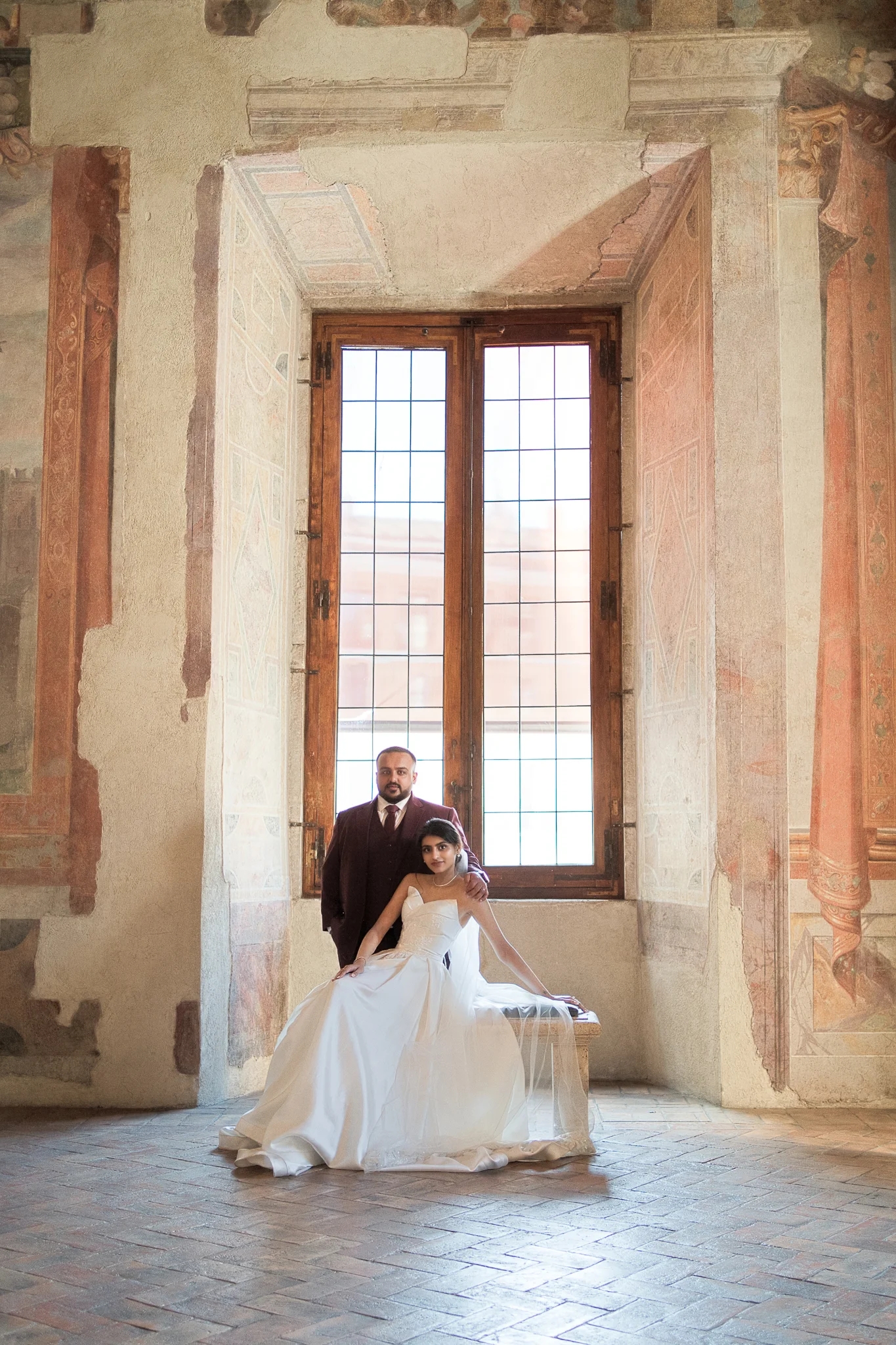 An elegant portrait of a couple in a historic Italian hall, a classic of Italy wedding photography styles.