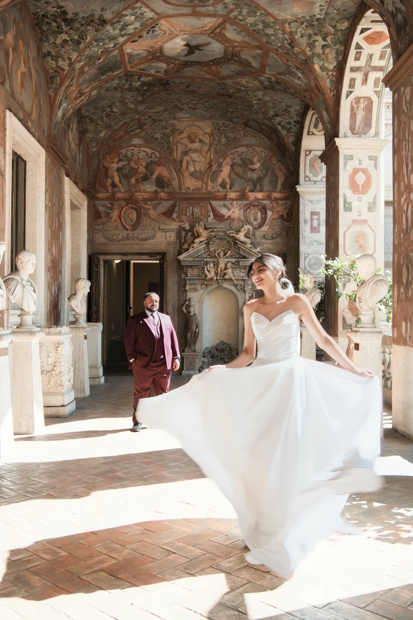 A bride in a white gown twirls in a historic villa, showcasing classic Italy wedding photography styles.