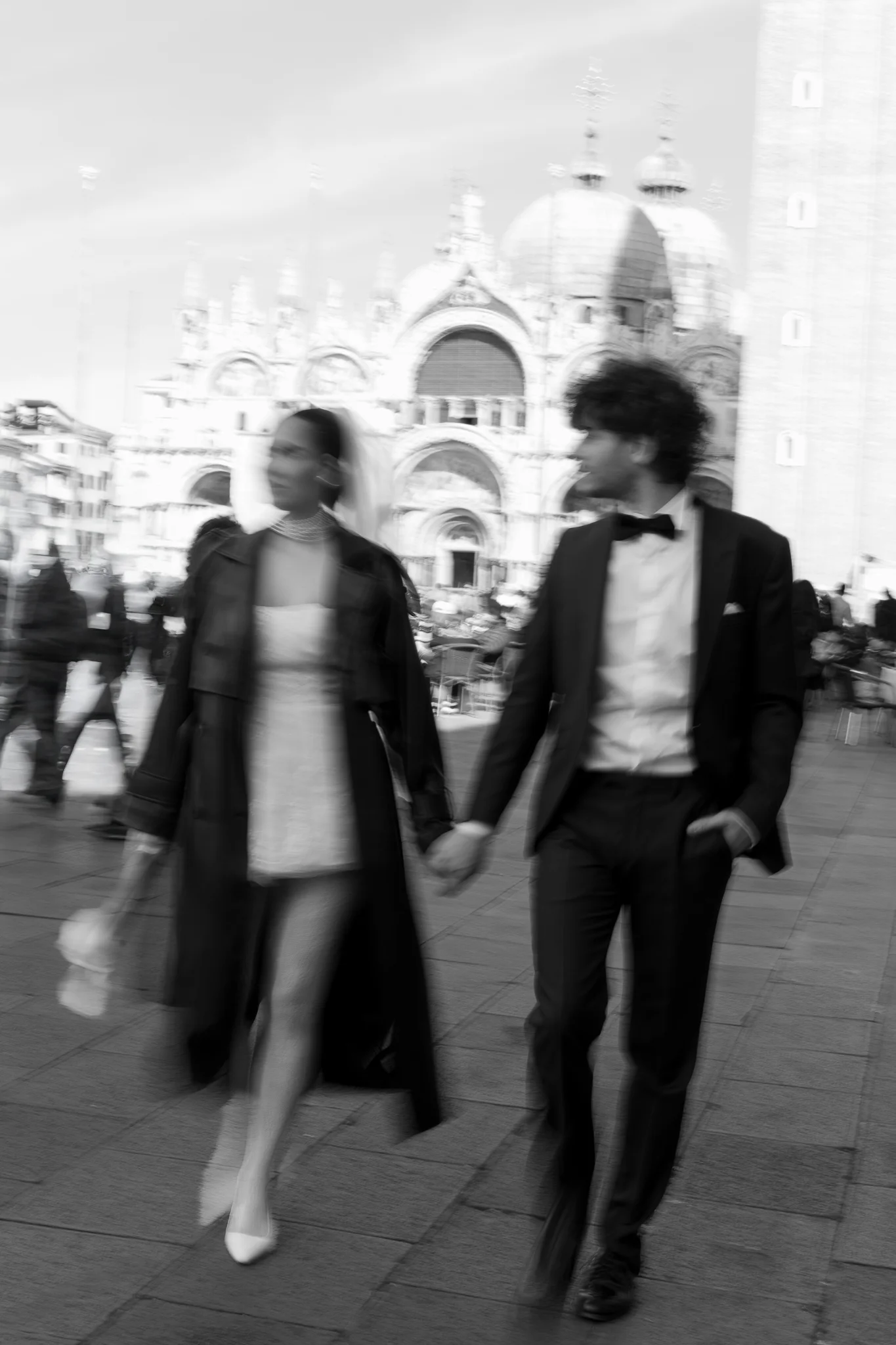 Artistic motion blur in black & white captures a stylish couple in a piazza, a modern Italy wedding photography style.