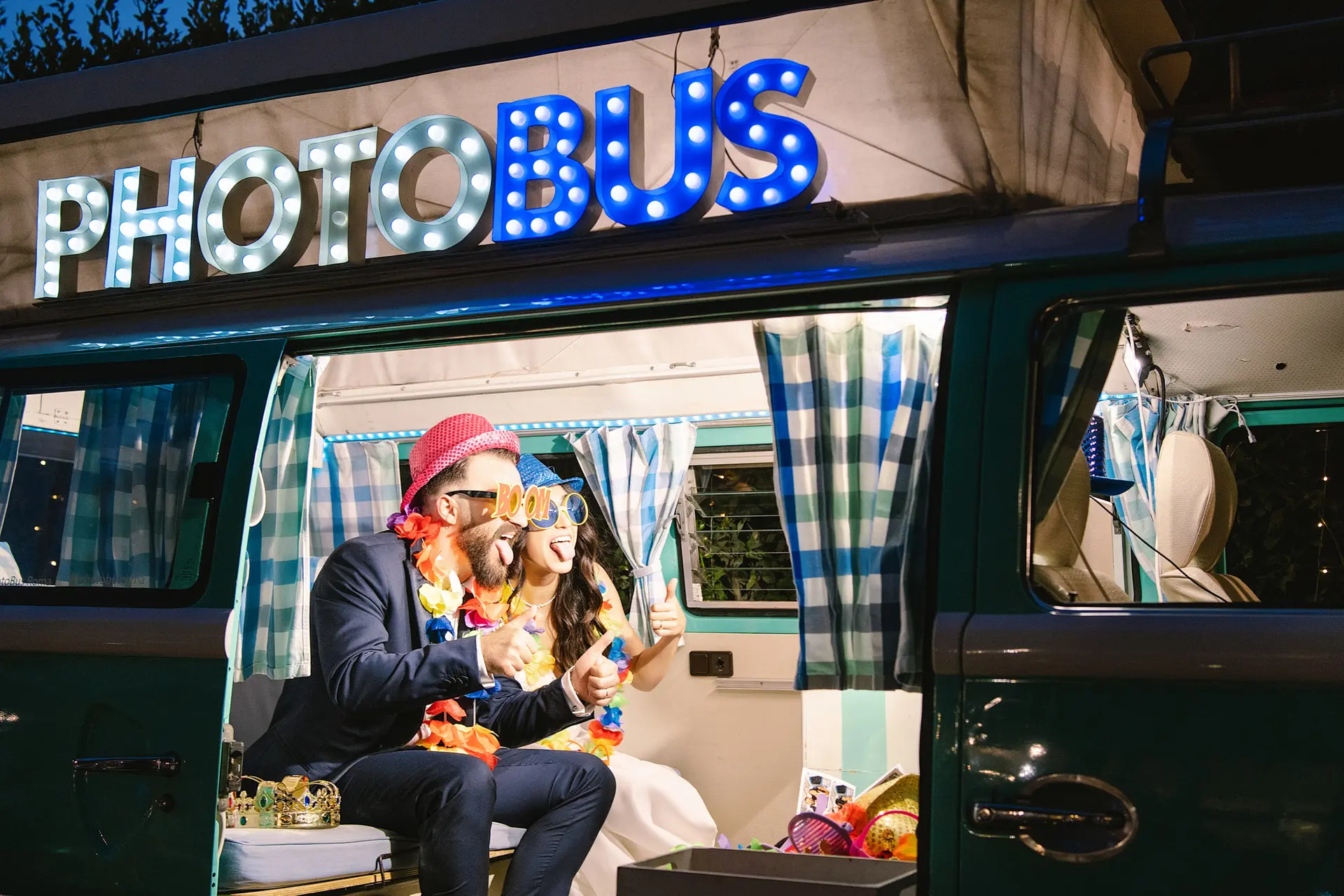 A professional photographer for Italy weddings captures a fun couple posing with props inside a vintage photobus.
