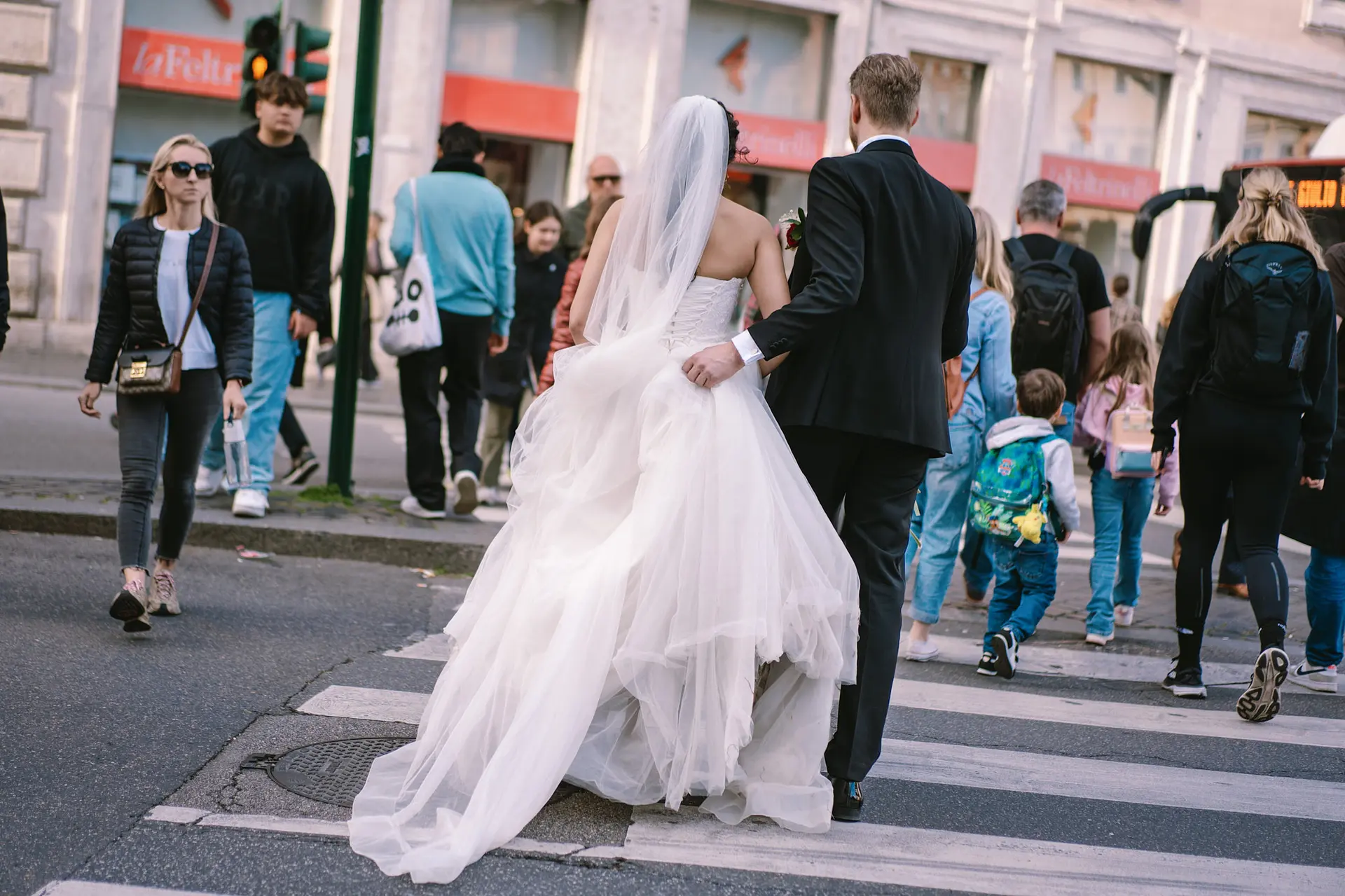 A bride and groom cross a busy street, a moment from their affordable destination wedding in Italy.