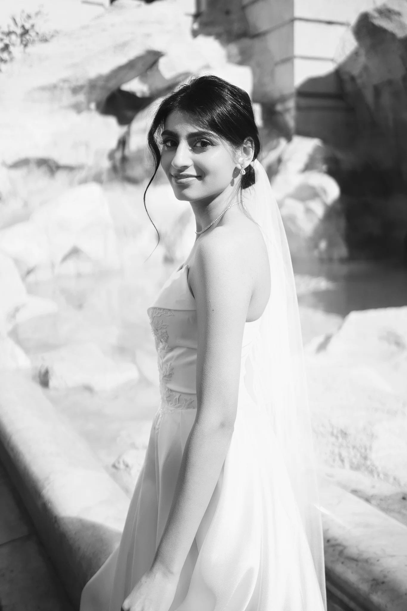 A timeless black and white portrait of a bride looking over her shoulder. A wedding photographer in Rome captured this.