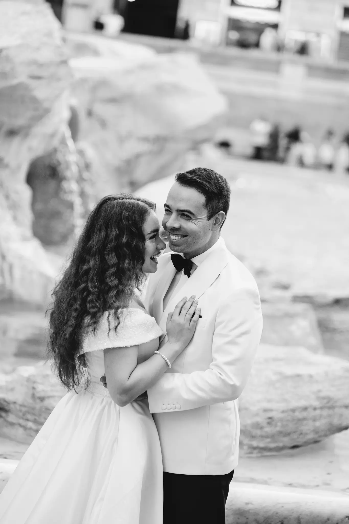 A joyful bride and groom share a laugh in this candid B&W image. A wedding photographer in Rome captured their happiness.